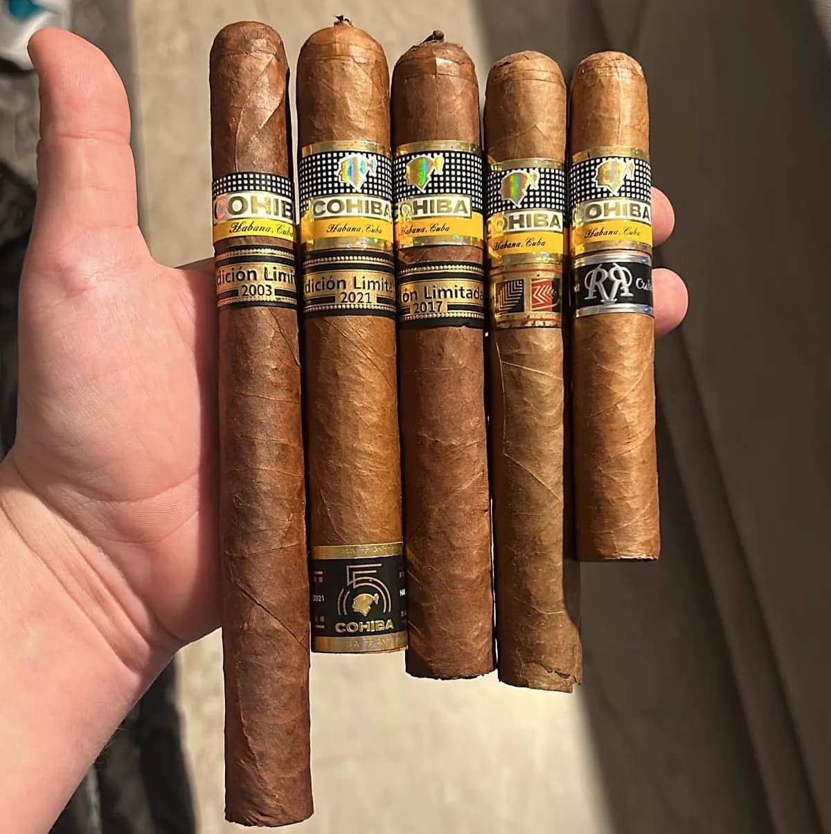 A hand holding five Cohiba Edición Limitada cigars