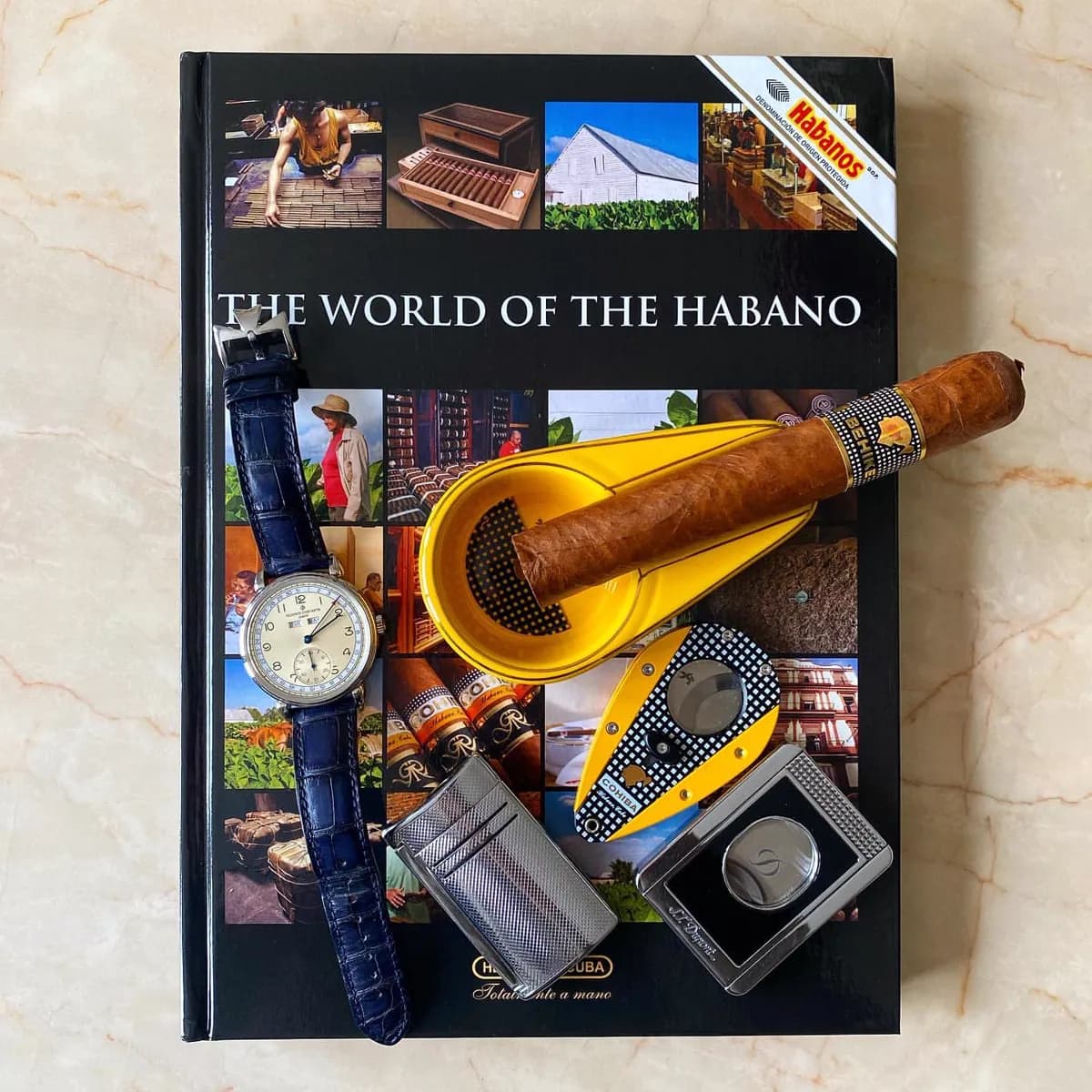 The World of the Habano book with a Cohiba, cutter and lighter